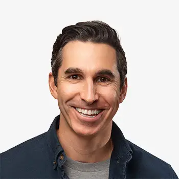 Smiling man with dark hair and a casual navy shirt, cheerful and approachable.