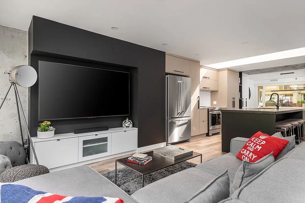 Sleek living room with large flat-screen TV, contemporary décor, and cozy seating area.