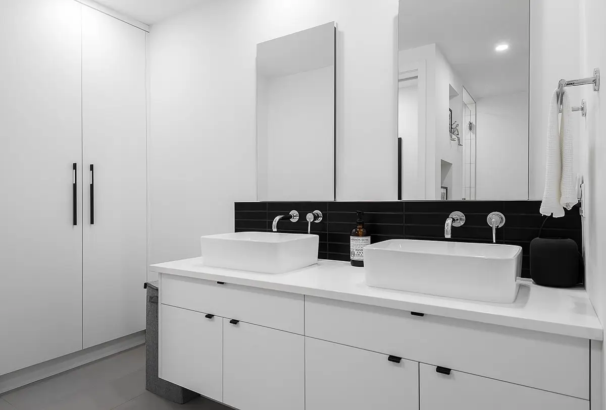 Modern bathroom with dual vessel sinks and sleek cabinetry for a clean look.