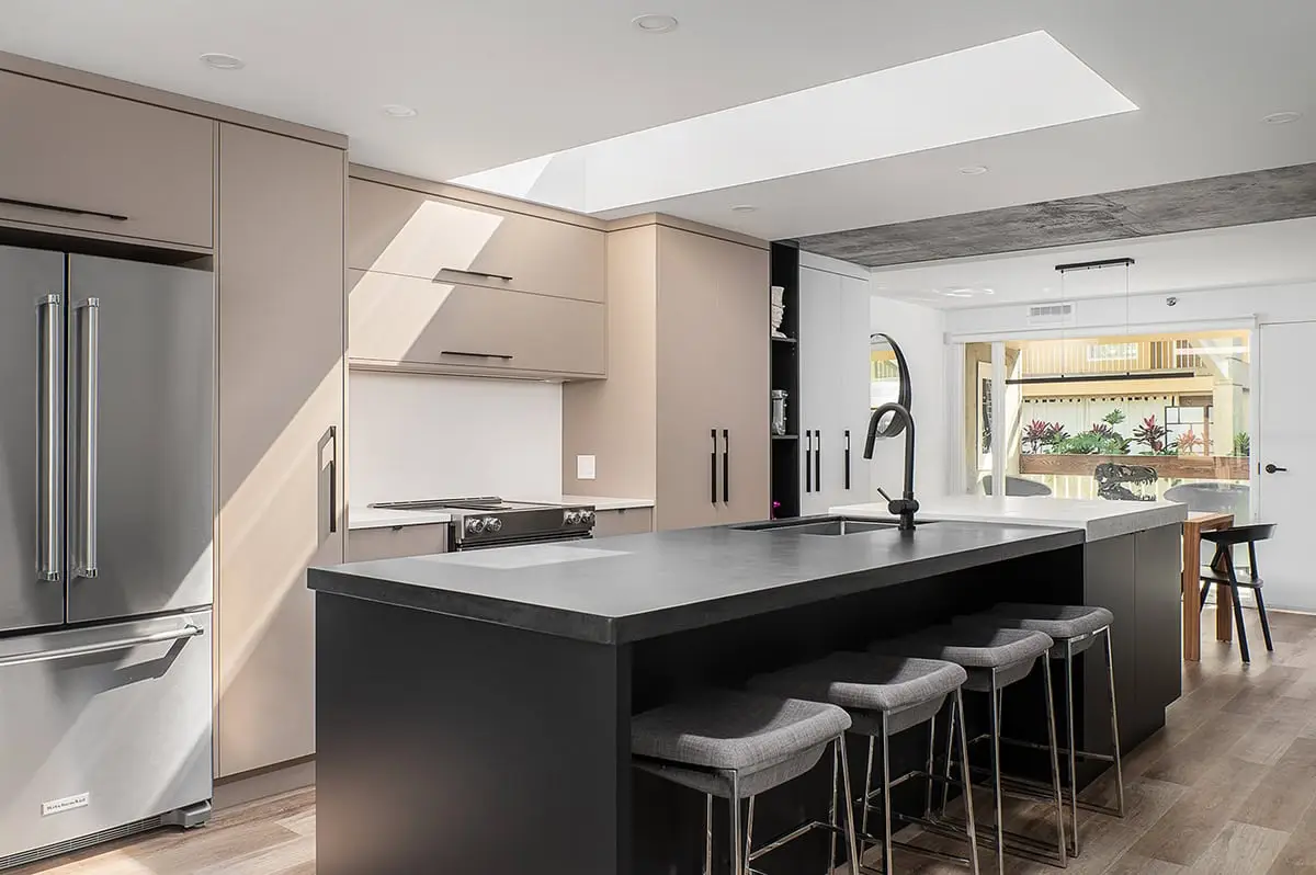 Contemporary kitchen with minimalist design, gray cabinets, and a large island for cooking and seating.