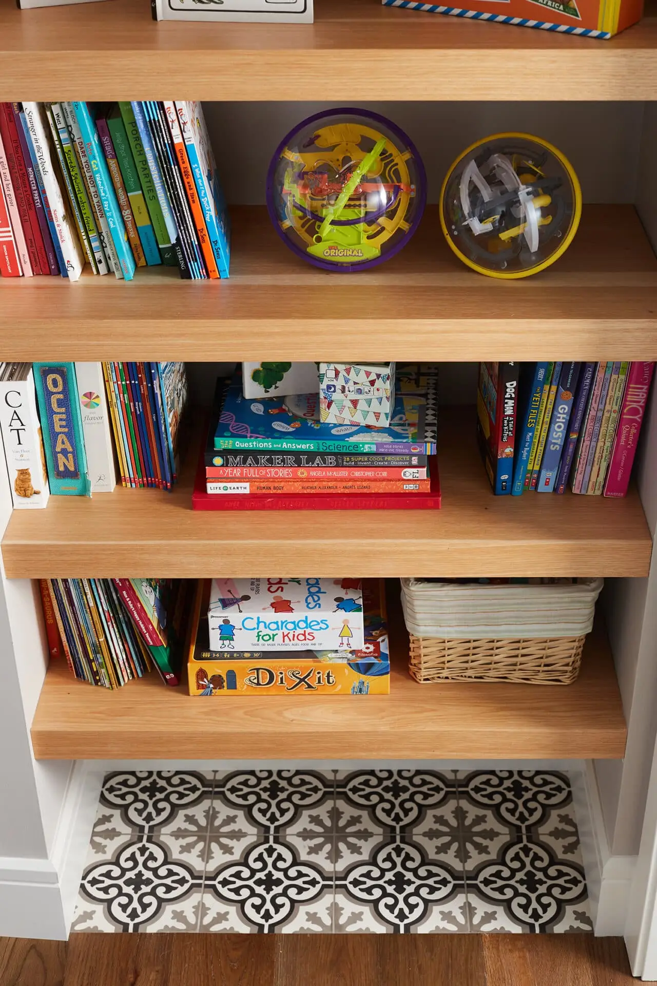 Colorful toy gecko balls on wooden shelf.