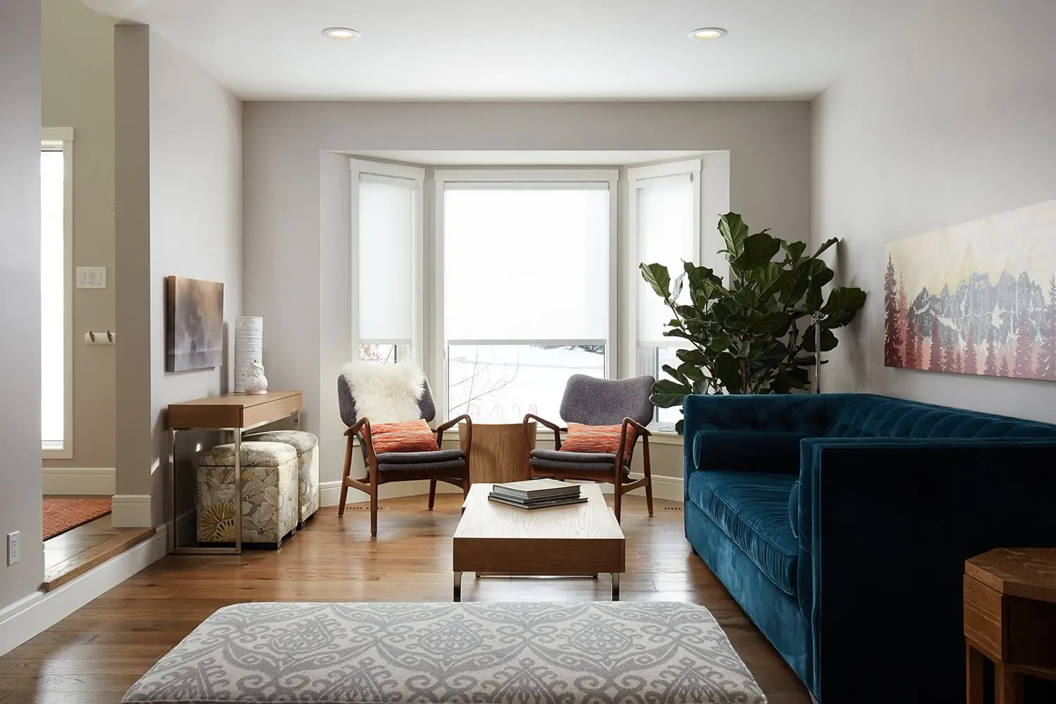 Bright living space featuring large bay window, stylish chairs, and vibrant decor accents.