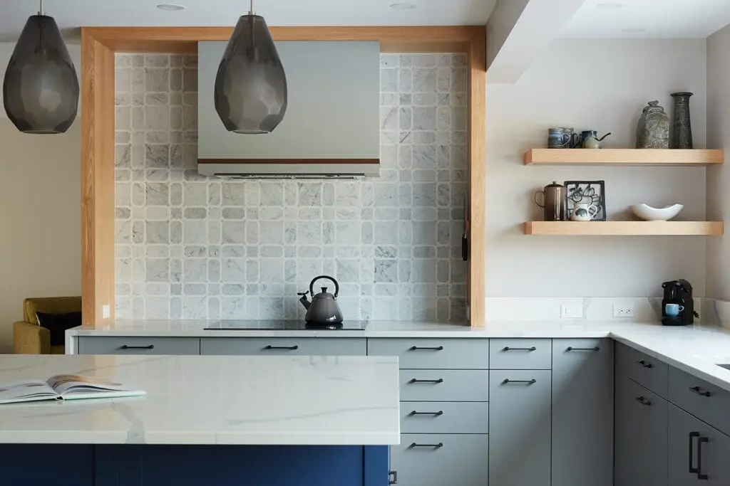 Kitchen decor with gray cabinetry, open shelves, and decorative ceramics, creating a contemporary and cozy ambiance.