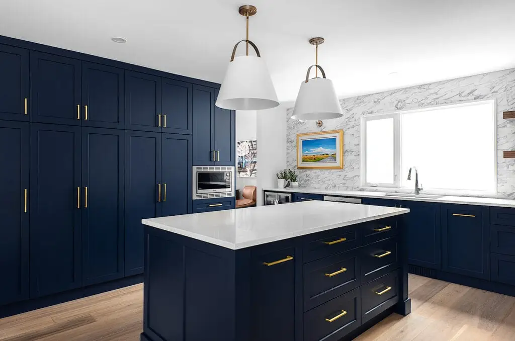 Beautiful navy kitchen cabinets with sleek gold handles and marble accents.