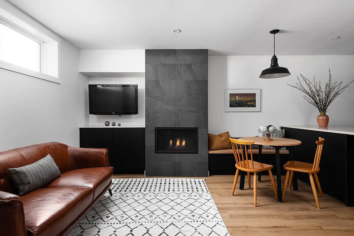 Bright living room with fireplace, leather sofa, and wooden dining set, stylish decor, and neutral tones.